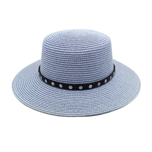 Détail du chapeau de paille bleu clair avec ruban noir et clous argentés