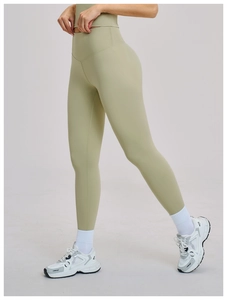 Detail of high-waisted yoga leggings in sage green showing V-shaped lifting seams