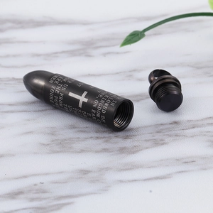 Macro detail of openable bullet cross pendant with engraved prayer and screw cap