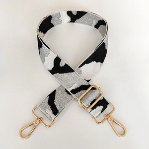 Close-up of adjustable camo shoulder strap with black and white jacquard and gold hooks