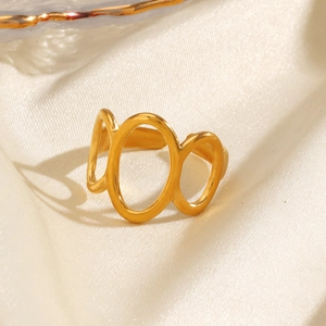 Bague ouverte géométrique ovale dorée minimaliste sur fond de tissu satiné crème