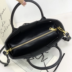 Top view of a black leather tote bag with gold metal zipper and spacious interior detail