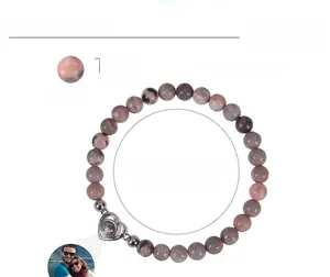 Macro shot of 6mm zebra stone beads and heart-shaped photo projection charm details