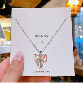 Dettaglio della collana con ciondolo a fiocco argento con pietra rosa e cristalli