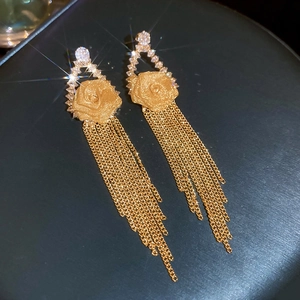 Detailed macro shot of gold flower earrings featuring multi-layer long tassel chains
