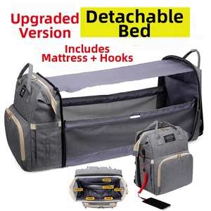 Detail of grey diaper bag expanding into a portable crib with USB port and storage pockets