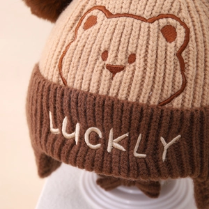 Detailed knit texture and bear embroidery on children's winter earflap hat
