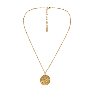 Detail view of golden coin necklace with Libra zodiac relief and delicate bead chain