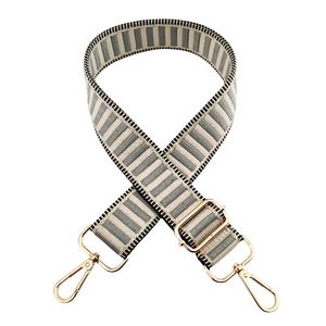 Detail of adjustable gray and white striped canvas bag strap with gold metal swivel hooks