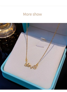 Nahaufnahme der vergoldeten LOVE-Kronenhalskette mit Zirkonia in blauer Geschenkbox