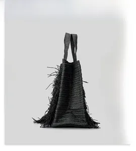 Detailed side view showing dense fringe texture on large woven beach tote bag