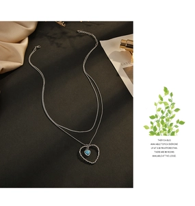 Détail d'un collier double épaisseur en acier inoxydable avec pierre bleue en cœur