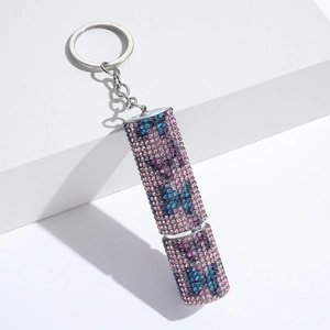 Detail of keychain with pink and blue rhinestone butterfly pattern on a perfume bottle charm