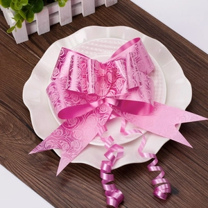 Detailed view of pink ribbon pull bow with rose pattern on white ceramic plates