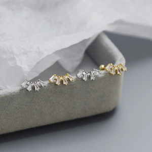 Macro shot of fan-shaped S925 silver stud earrings with cubic zirconia in gold and silver