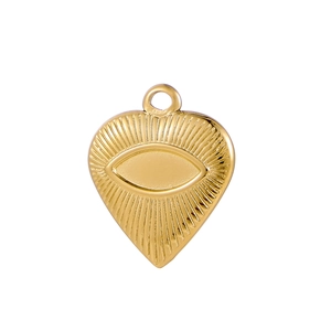 Detailed view of heart-shaped gold pendant featuring embossed eye and sunburst design