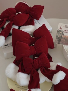 Macro detail of Christmas red velvet bows with white faux fur trim on festive backdrop