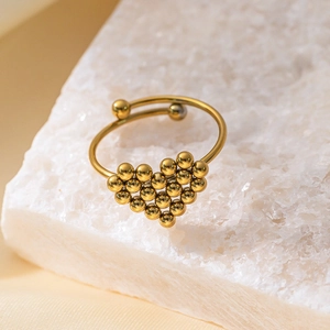 Bague cœur dorée ajustable en petites perles métalliques sur une roche de cristal