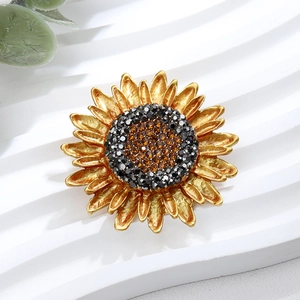Macro view of sunflower brooch with golden petals and black crystal center detail