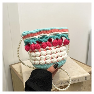Detail of hand-knitted cherry bucket bag with colorful yarn and pearl beaded strap