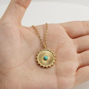 18k gold plated sunburst necklace with turquoise center stone pendant on hand