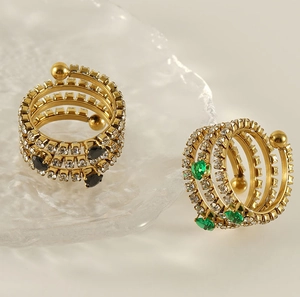 Detail of gold spiral rings with pavé zircon, green and black teardrop gemstones