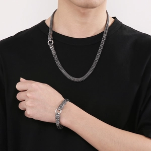 Dettaglio della collana e bracciale a scaglie di serpente argento con chiusura a doppia testa