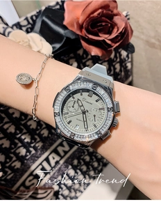 Detail of luxury silver watch with crystal bezel and grey dial paired with a bracelet
