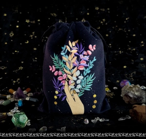Detail of dark blue velvet drawstring bag with colorful botanical prints for tarot storage