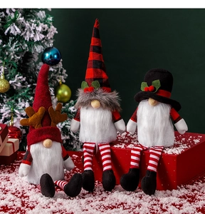 Three festive Christmas gnomes with striped legs on red gift boxes by a Christmas tree