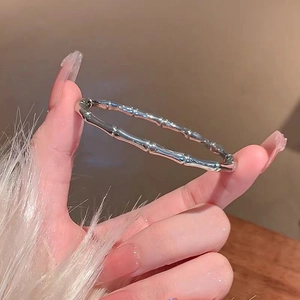 Dettaglio macro di un bracciale a rigido in bambù argento con finitura in acciaio lucido