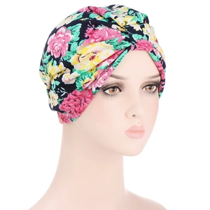Floral paisley print cotton turban hat with twist knot design for women shown on a mannequin