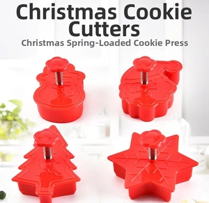 Close-up of four red Christmas cookie cutters with spring-press handles for baking