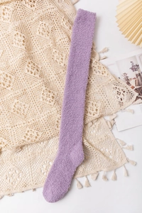 Detail view of a soft purple coral fleece over-the-knee sock on a stylized background