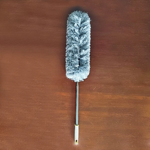 Detail of extendable microfiber duster showing grey fiber head and telescopic metal pole