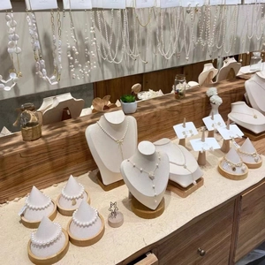 Macro detail of pearl necklace and earring collection on wooden display stands