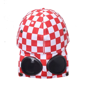 Detail of red and white checkerboard baseball cap with built-in pilot goggles on back