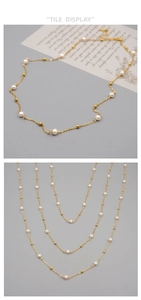 Vue détaillée du long collier de perles d'eau douce avec billes dorées sur fine chaîne acier
