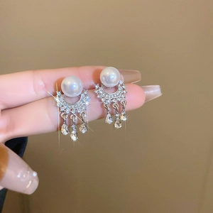 Detail of silver pearl tassel earrings with shimmering crystals and zircon accents