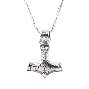 Macro detail of vintage silver Thor's Hammer Mjolnir pendant with intricate Viking carvings