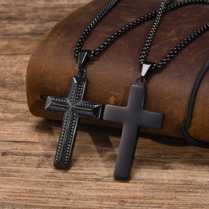 Two black stainless steel cross necklaces with textured and smooth finishes on leather