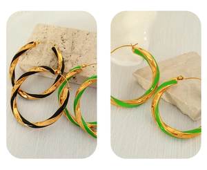 Detailed macro of gold-plated twisted hoop earrings with enamel coating and metallic shine