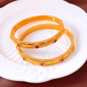 Détail d'un bracelet vintage plaqué or 24 carats avec textures et pierres précieuses