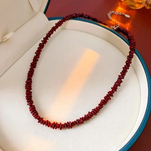 Detalle de collar de cuentas de piedra roja con cierre plateado en estuche de joyería