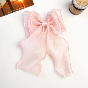 Close-up of pink pearlescent ribbon bow hair clip with delicate organza texture