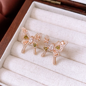 Close-up of vintage bow earrings in gold finish with colorful zircon stones in a box