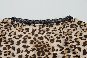 Detail of leopard print crop top featuring black lace trim and circular neckline texture