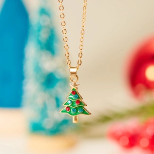 Close-up of golden Christmas tree necklace with green enamel and colorful rhinestones