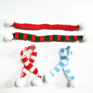 Detail von vier Mini-Weihnachtsschals aus Strick mit Pompons in Streifen und Uni-Farben