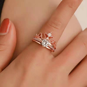 Close-up of rose gold crown ring set with a central zircon and 100 languages projection